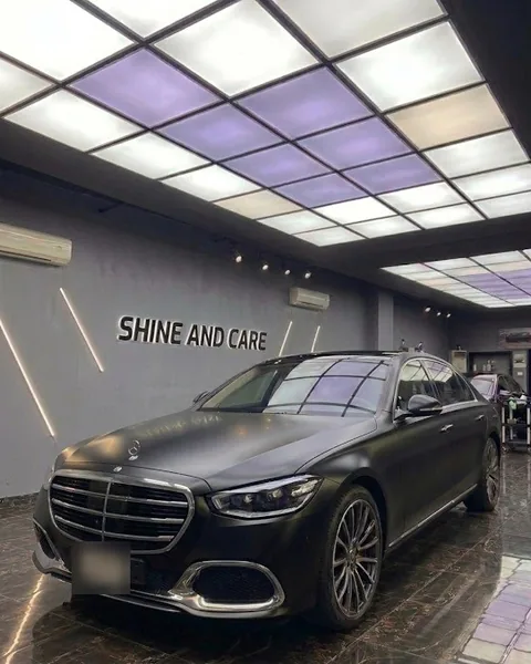 سيارة مرسيدس الفئة S سوداء مطفية أمام جدار Shine and Care
